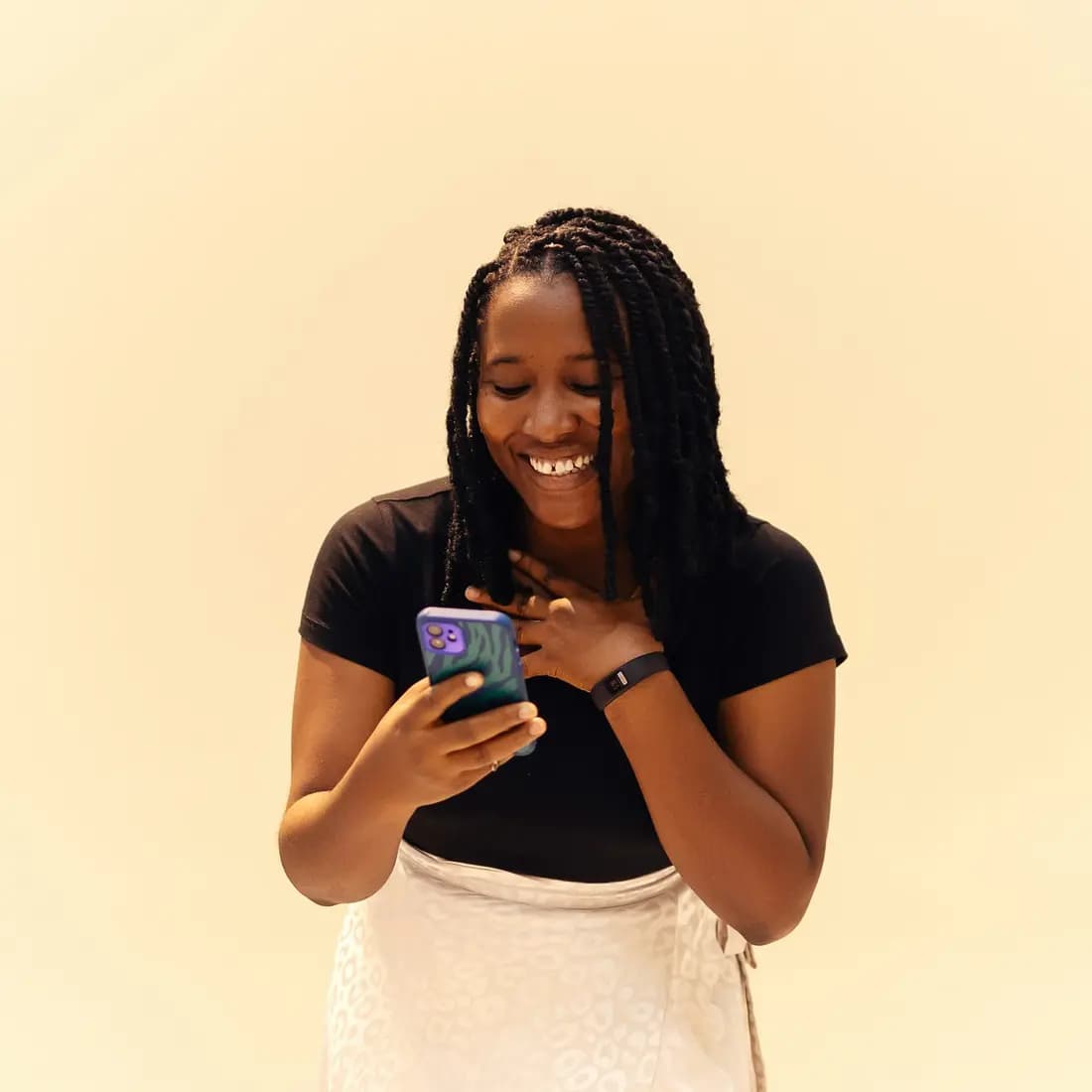 Une acheteuse sourit devant son téléphone en parcourant des annonces.